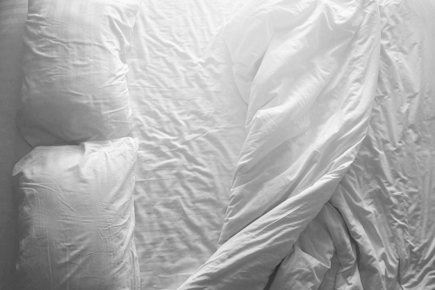 messy-double-bed-two-pillows-and-blanket-on-white-cover-sheets-top-view_6351-110